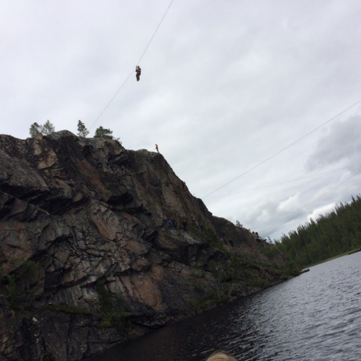 Person som bruker zipline over et vann.